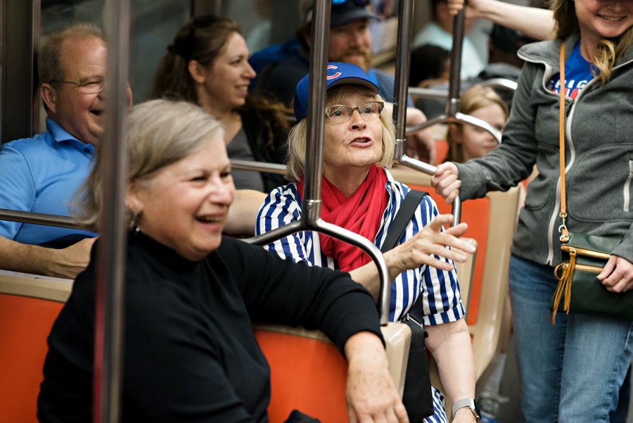 Family of the wedding couple dressed in baseball hats on the subway.